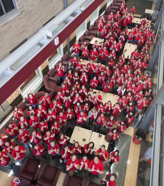Atrium filled with UW Law students making UW's W with their hands